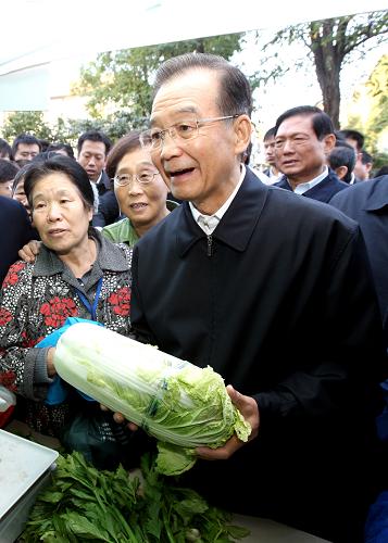 10月1日一大早,中共中央政治局常委、国务院总理温家宝来到北航社区,了解周末蔬菜直销市场情况,并向居民们致以节日问候。这是温家宝在询问白菜价格。新华社记者 姚大伟 摄