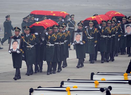 1月19日,礼兵护送八位烈士的灵柩,灵柩上覆盖着中华人民共和国国旗。当日,专程接运在海地地震灾害中遇难的八位中国维和警察灵柩的专机抵达北京首都国际机场。 新华社记者金良快摄