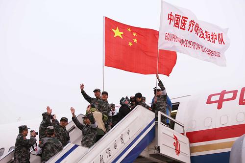 1月24日,中国医疗防疫救护队队员向送行的人挥手道别。 新华社记者 陈建力 摄