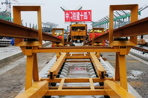 7月17日,中国铁建十四局集团京沪高铁铺轨工班的工人们正在铺设通道,为正式铺轨进行准备。京沪高铁先导试验段北段将于7月19日开始率先从徐州向蚌埠铺轨,南段将于8月中旬从南京向蚌埠铺轨,10月底将完成试验段铺轨。京沪高速铁路全长1318公里,全线纵贯京津沪三大直辖市和河北、山东、安徽、江苏四省,是我国目前最长的客运专线之一。新华社发(刘文摄)