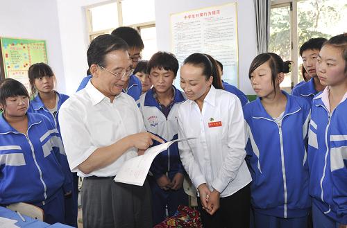 9月10日是第26个教师节,中共中央政治局常委、国务院总理温家宝与明年毕业的北京师范大学首批免费师范生代表一起来到河北省兴隆县六道河中学,看望广大师生,听中学教师上课,并与中小学教师和免费师范生代表座谈。 这是温家宝与九年级2班的同学一起上完语文课外阅读课后,与师生交流。 新华社记者黄敬文摄
